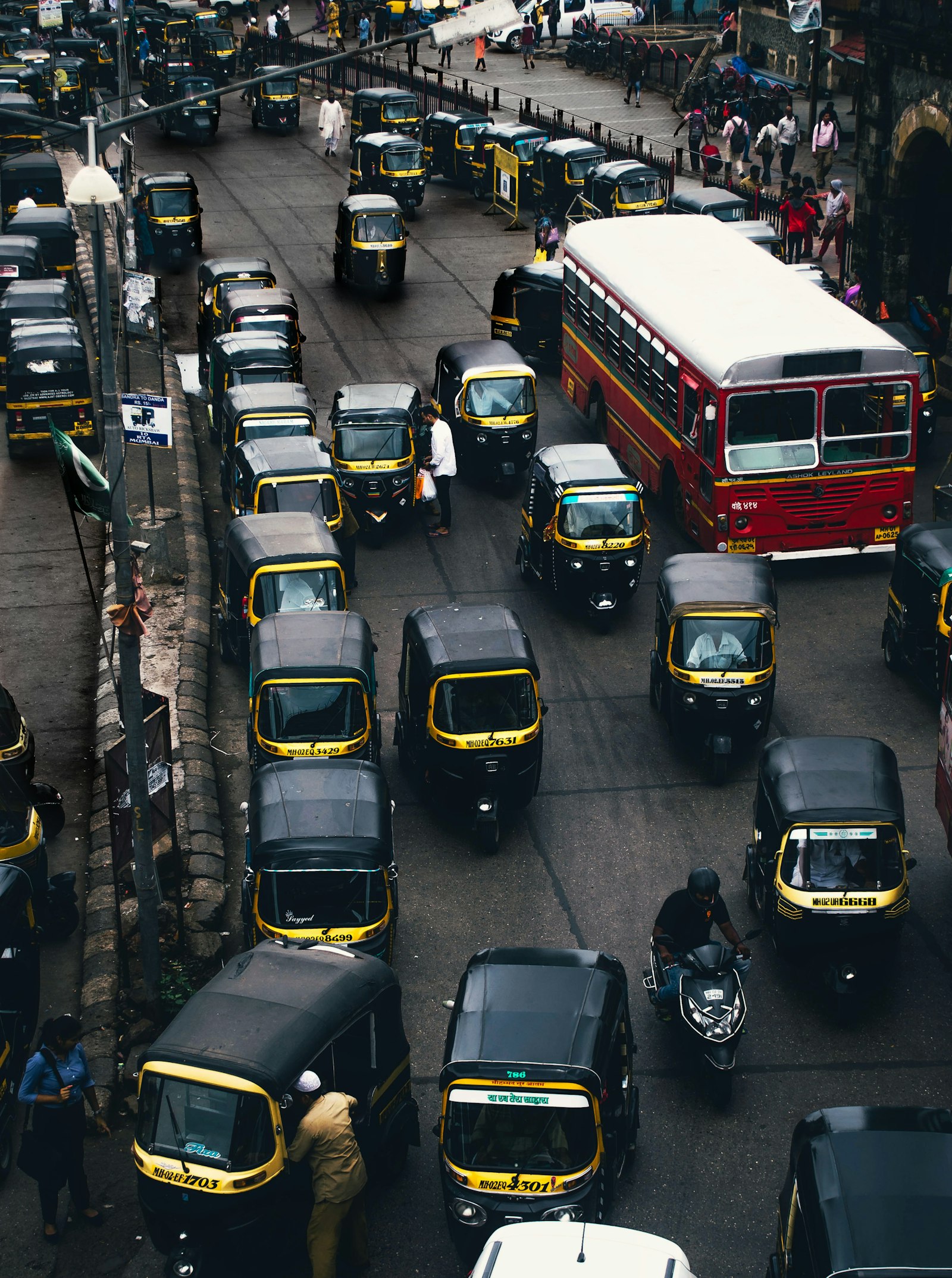 Yellow and black autos moving through a busy Indian street